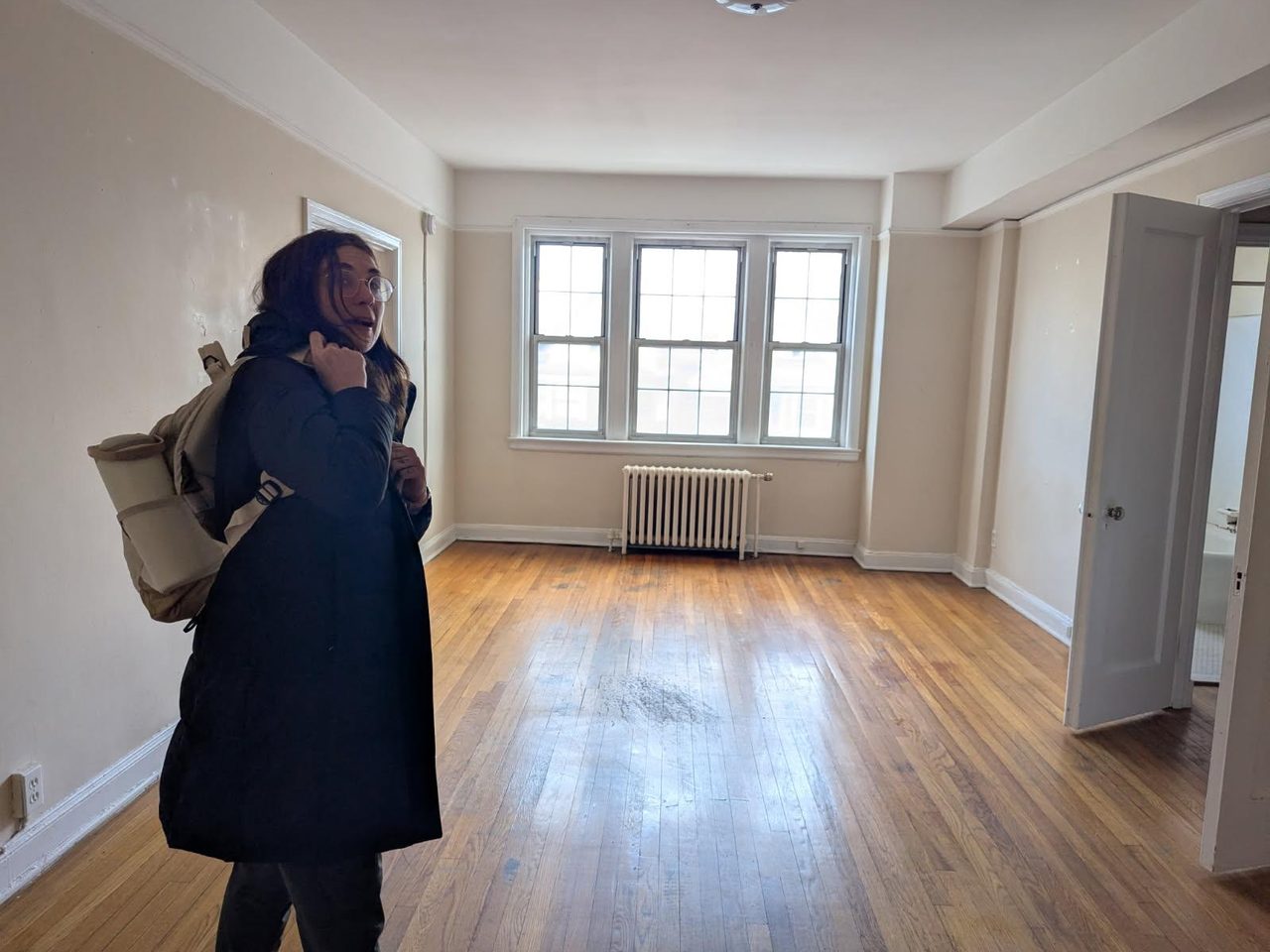 Olivia standing in an empty apartment on moving day
