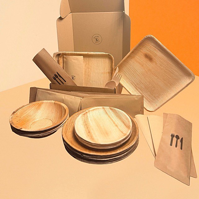 The 7 day kit: palm-leaf plates and bowls, wrapped cutlery, and napkins in the box